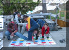 Die Kinder spielen Twister mit der Kellnerin